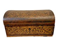 Front view of antique wooden box showing intricate filigree inlay and keyhole.