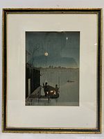 Frontal shot of framed woodblock print showing a moonlit river scene with figures in a boat