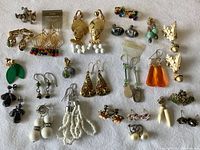 Photo showing a collection of various vintage earrings including gold-tone, bead, clip-on, and pierced styles.