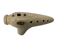 Cream-colored ceramic ocarina shaped like a potato with finger holes on top and bottom, showing wear and a partially worn gold decal.