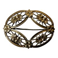 Front view of oval floral design sterling silver and 14K gold pin, showing intricate petal details and openwork elements.