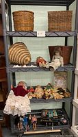 Wide view of shelving with multiple dolls, baskets, and accessories
