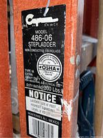 Close-up of the ladder's label showing model number 486-06, details on fibreglass, OSHA compliance, duty rating 300 lbs, and 6 feet ladder size.