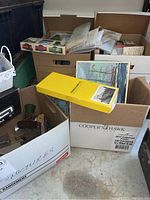 Three large boxes with various model train structures and boxes with packaging including a yellow Black Bart Mine kit box and a picture of a sailing ship box.