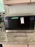 Front view of Panasonic inverter microwave oven showing control panel and size label