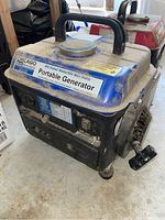 Blue and black Chicago portable generator with handle and recoil pull start, viewed from front right side showing the model label and power output info.