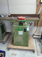 Full front view of green jointer on swivel cart