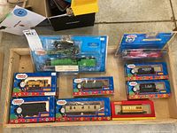 Top-down view of all items in the lot including boxed engines and train cars in a wooden tray