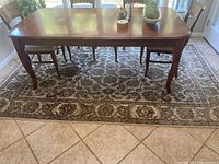 Full view of the rectangular area rug under a dining table set, showing overall pattern and size in situ.