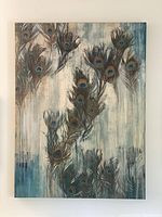 Canvas wall art displaying multiple realistic peacock feathers with jewel-toned eyes in blue and green hues on a muted blue, cream, and beige background.