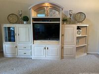 Front view of the custom-built solid wood 3-piece wall unit with open shelving and storage compartments, built for accommodating a 45 inch TV and entertainment devices.