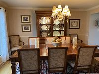 Full dining set: table, eight chairs, china cabinet in background