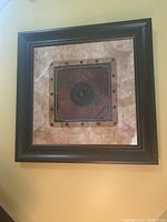 Full view of framed multi-dimensional medallion wall art hung on a wall.