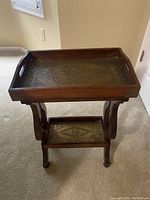 Front view of the wood accent table showing the removable tray top with stamped metal and curved legs.