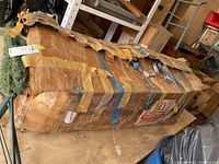 Photo showing the box containing the artificial Christmas tree secured with multiple layers of tape, showing signs of wear.