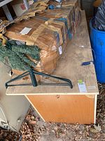 Photo of the full desk showing the top surface, the side panel and items on it including a wrapped package and a small artificial wreath.