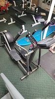 Full view of a Life Fitness elliptical machine with black frame, foot pedals, handles, and console in a gym setting.