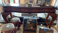 Full view of wood sofa table showing detailed carvings and carved legs with claw feet, plus visible damage on corners and surface edges.