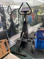 Full view of the black StairMaster Free Climber machine showing pedals, handlebars, and surrounding gym environment.