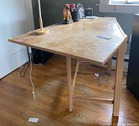 Full view of the Stanley wooden corner desk showing stained and discolored desktop surface and angled legs.