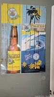 Pacifico Claro beer themed wooden wall art with bottle and surfing scene, hung on wall.