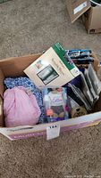 Box containing various women's clothing items including pajamas, hosiery, and packages of leggings and pantyhose