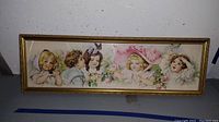 Full view of framed child-themed print featuring five children and floral accents.