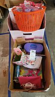 Overview of the lot including pink storage bins, boxed and loose toys, and various small bags and containers.