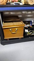 Wooden jewelry box with brass handle on shelf