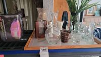 Wide shot of tray holding nine vases including one with faux plant