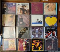 Overview photo of 12 music CD albums showing album cover art and titles.