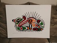 Front view of the First Nations style print depicting a sea otter in traditional indigenous art design with prominent colors black, red, green, and orange on white background.
