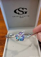 Silver toned bracelet inside branded George Smith box, showing heart-shaped rainbow topaz stone with clear stones accent