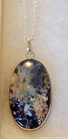 Close-up image of the sterling silver necklace showing the 18-inch chain and oval multicolored stone pendant.