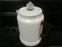 Full external view of the white metal coffee percolator with black handle and clear knob on lid.