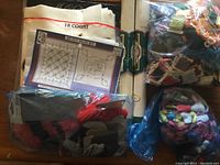 Photo showing folded 18 count fabric cloth, quilt block pattern sheet, and bags of bundled embroidery threads.
