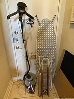 Photo of full set of ironing equipment including several ironing boards and clothes steamer