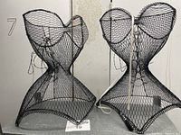 Two black wire corset-shaped jewelry holders side by side, showing full structure and mesh design.