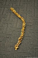 Full-length view of bracelet laid flat on textured surface showing braided multi-strand pattern