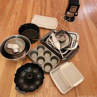 Photo showing assortment of cooking and baking pans, mixing bowls, immersion blender, metal canister, and Mr. Coffee pot with metal canister holder.