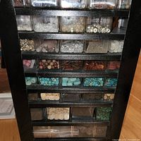 Full view of multi-drawer organizer filled with various beads and jewelry making components including glass, turquoise, red, white, and shell beads.