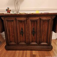 Front view of the closed wooden Italian Provincial server showing detailed paneled double doors with antique-style brass handles.