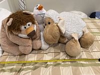 Photo showing three large stuffed animals: brown-maned lion, white sheep with beige face, and Olaf plush character.
