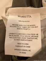 Close-up of Wamsutta tag showing 100% polyester material and care instructions on duvet set