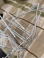 Three white metal shower caddies piled together on fabric surface.