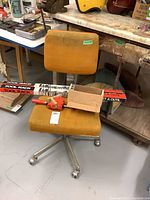 Yellow office chair with corner clamp, tool racks and pocket jig on seat