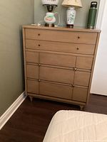 Front view of vintage Kroehler wood dresser showing the drawer arrangement and the light wood finish with brass knobs and handles.