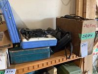 Shelf with the jigsaw blue plastic case and the soldering kit cardboard box labeled 'Jig Saw'.