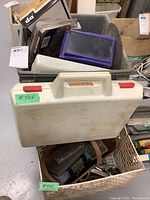 White plastic hard case labeled Stanley among other stored items