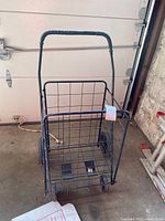Front angle view showing entire wire metal shopping cart with four wheels and handle with textured grip.